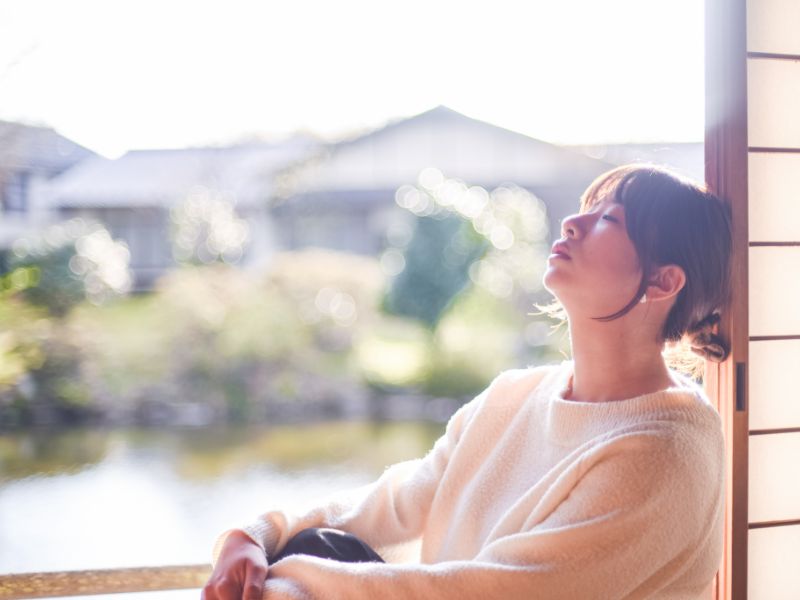 庭の見える窓辺で読書する様子